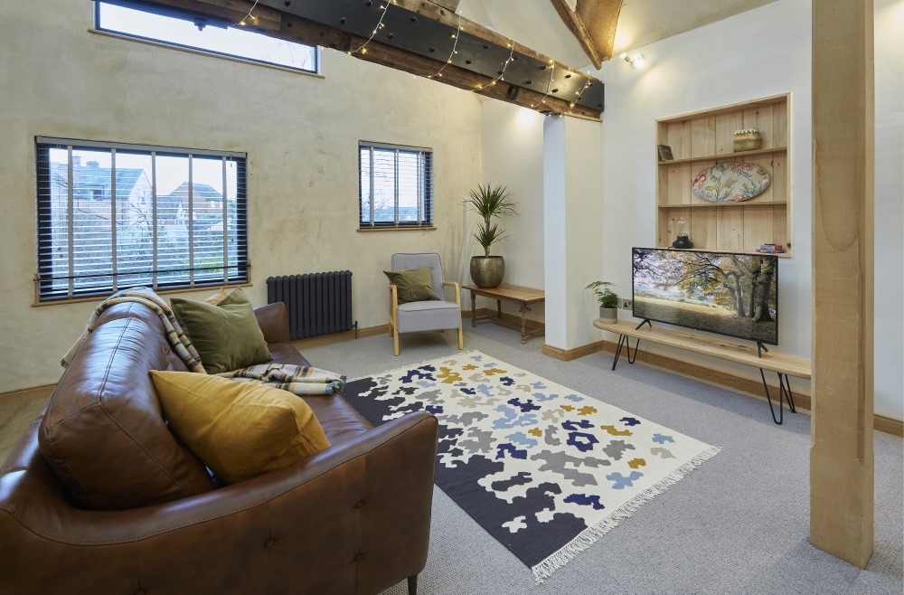 The living room showing the layout (including television) and windows to the garden