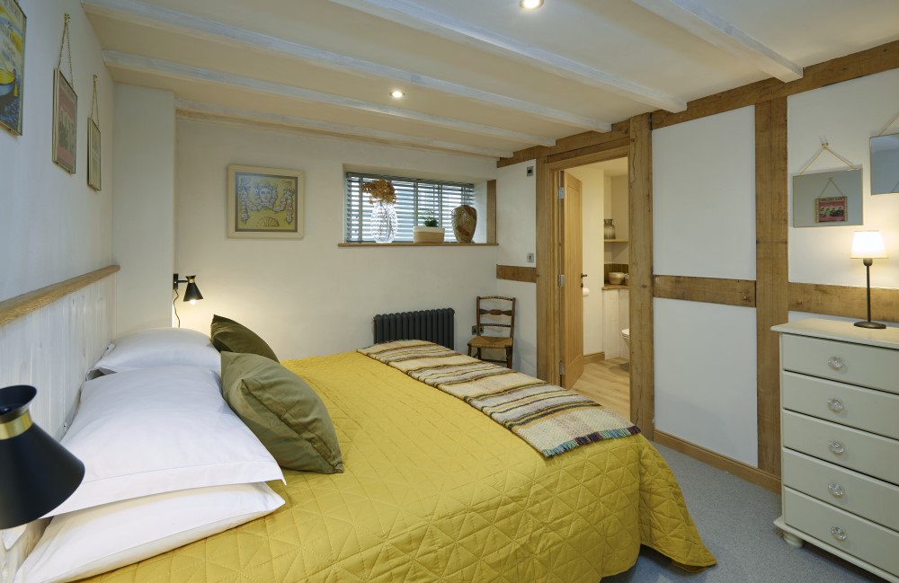 The king size bed and chest of drawers in the second bedroom, looking toward the door to the ensuite bathroom