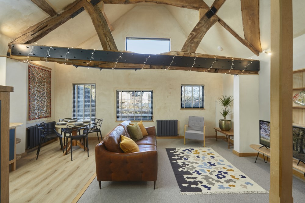 The living room where guests can relax and admire the large oak beam that spans it