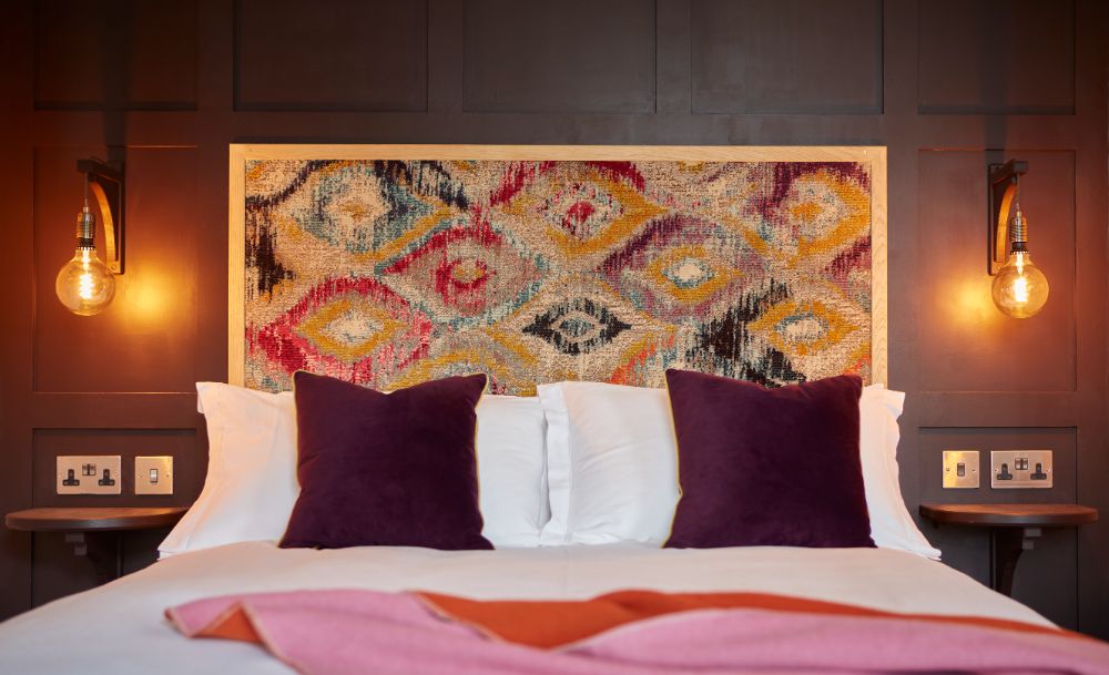 The king size bed, showing the headboard tapestry and colourful pillows