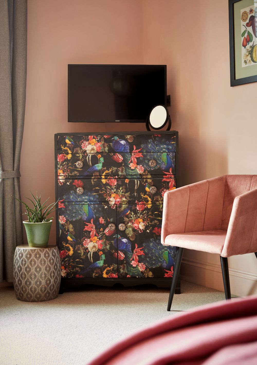 The colourful chest of drawers with TV above