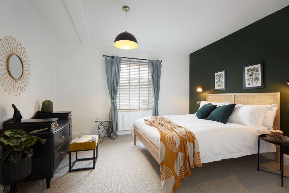 The bedroom filled with natural light and colour, showing the king-sized bed
