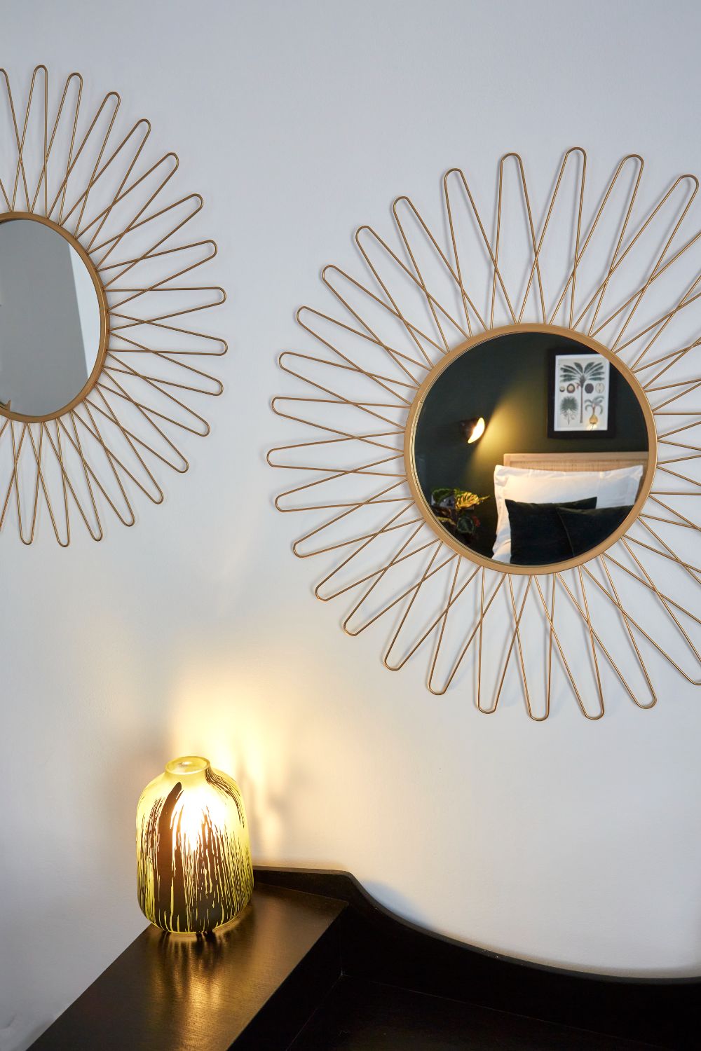 The 2 ornate bedroom mirrors reflecting the bed